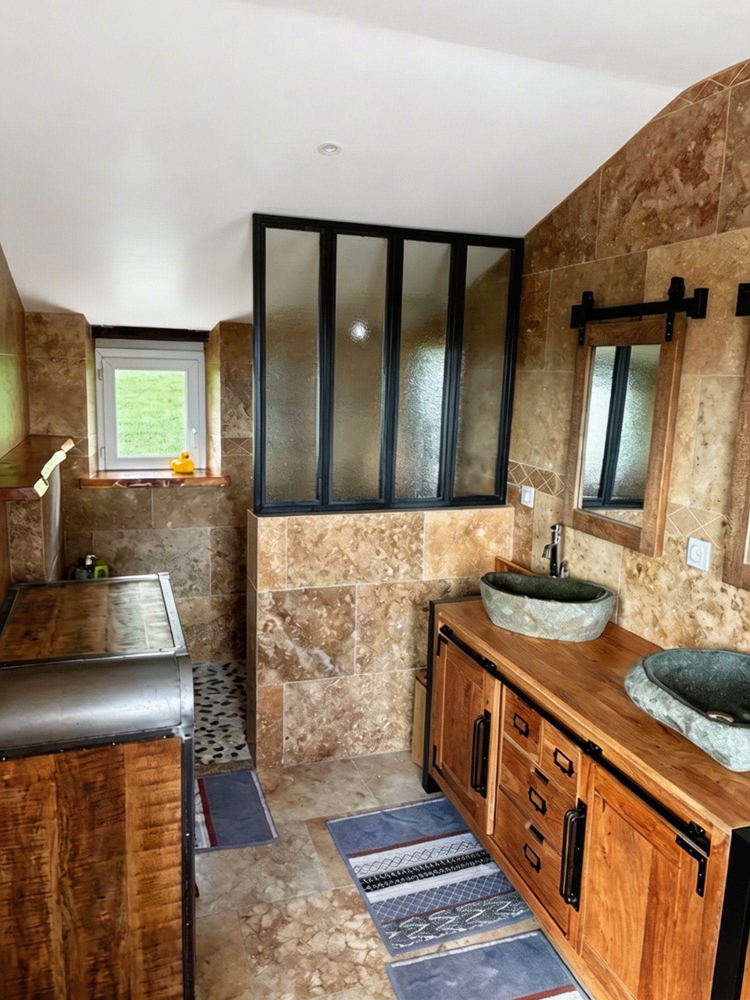 Rénovation salle de bain travertin Tarbes - verrière atelier noire, double vasque pierre, sol galets